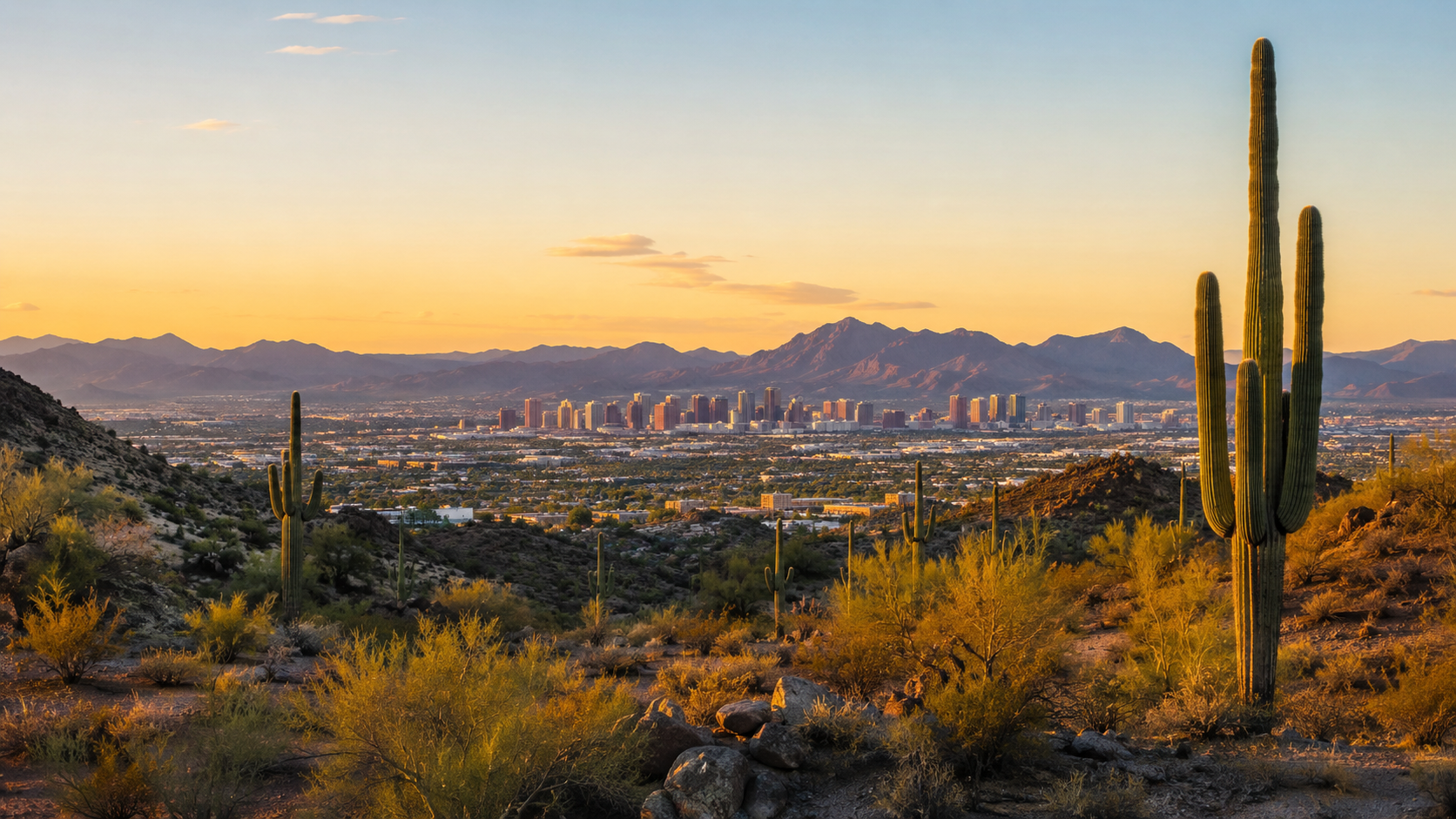 Arizona desert at sunset with saguaro cacti, Phoenix skyline and distant mountain views in the United States.