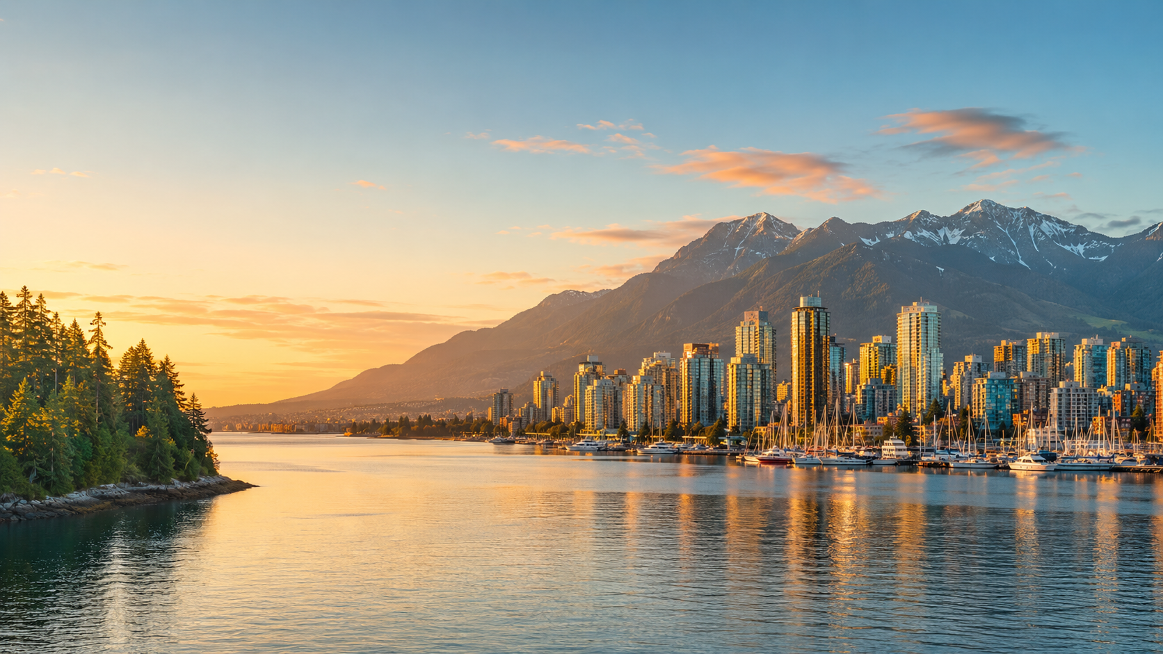British Columbia waterfront at golden hour with Vancouver-style skyline, marina, forested shoreline and snow-capped mountains.