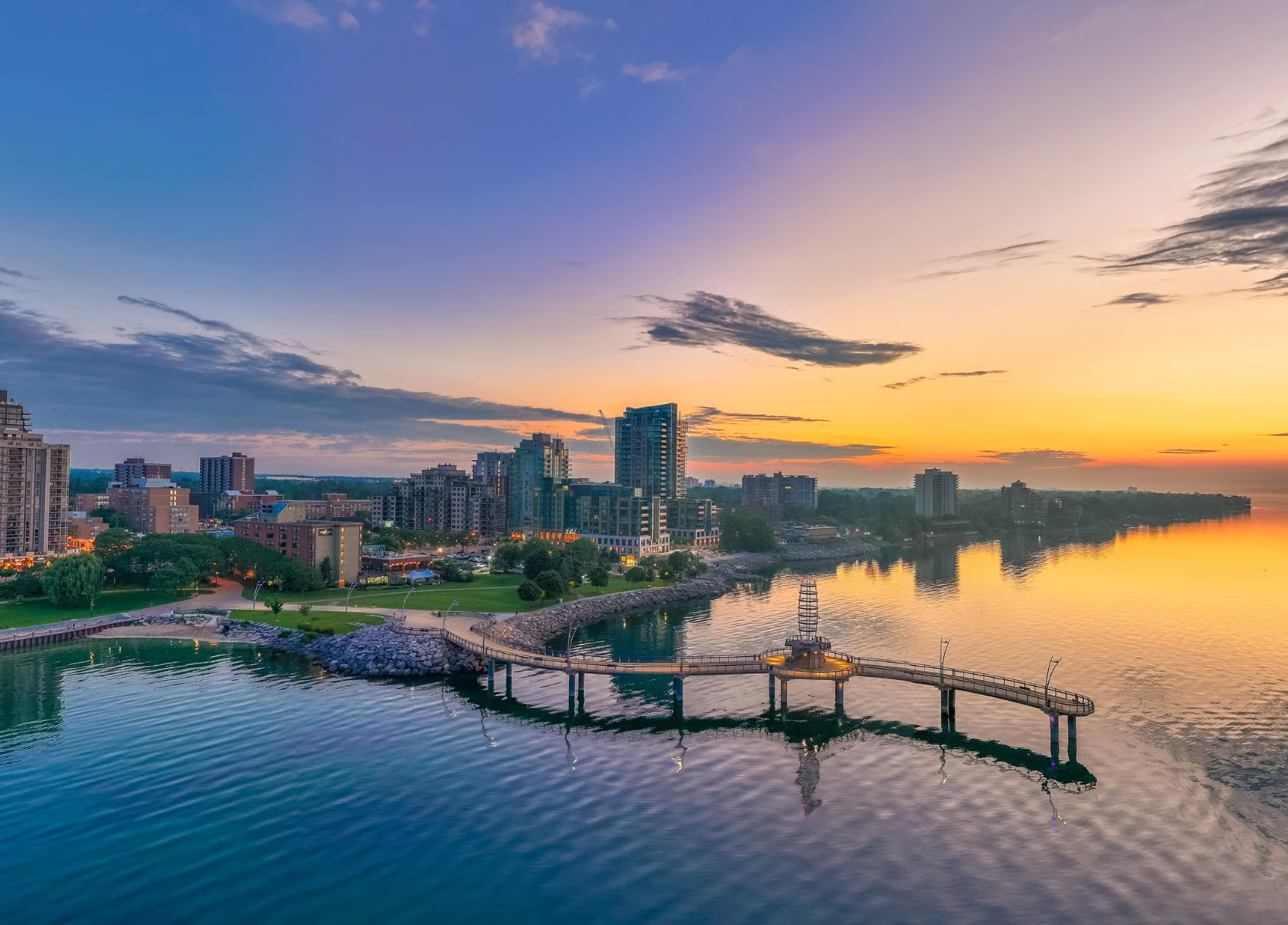 Aerial view of Burlington waterfront and Brant Street Pier on Lake Ontario with downtown skyline at sunset.