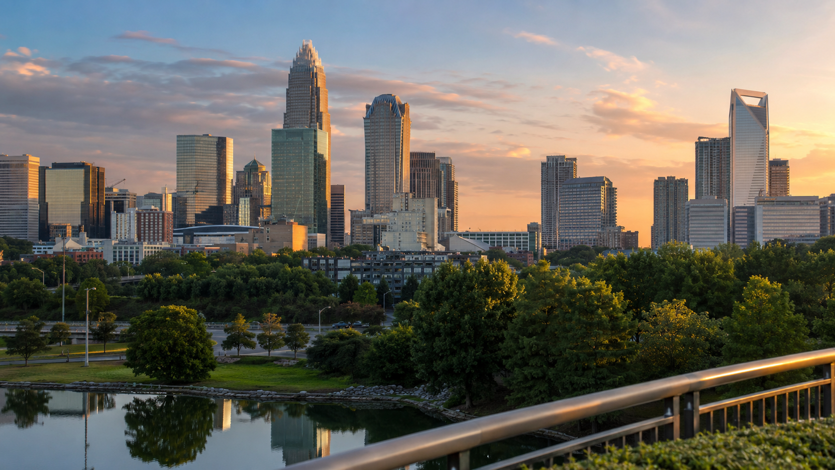 Charlotte skyline at golden hour with Uptown skyscrapers, green park space and city reflections in North Carolina.