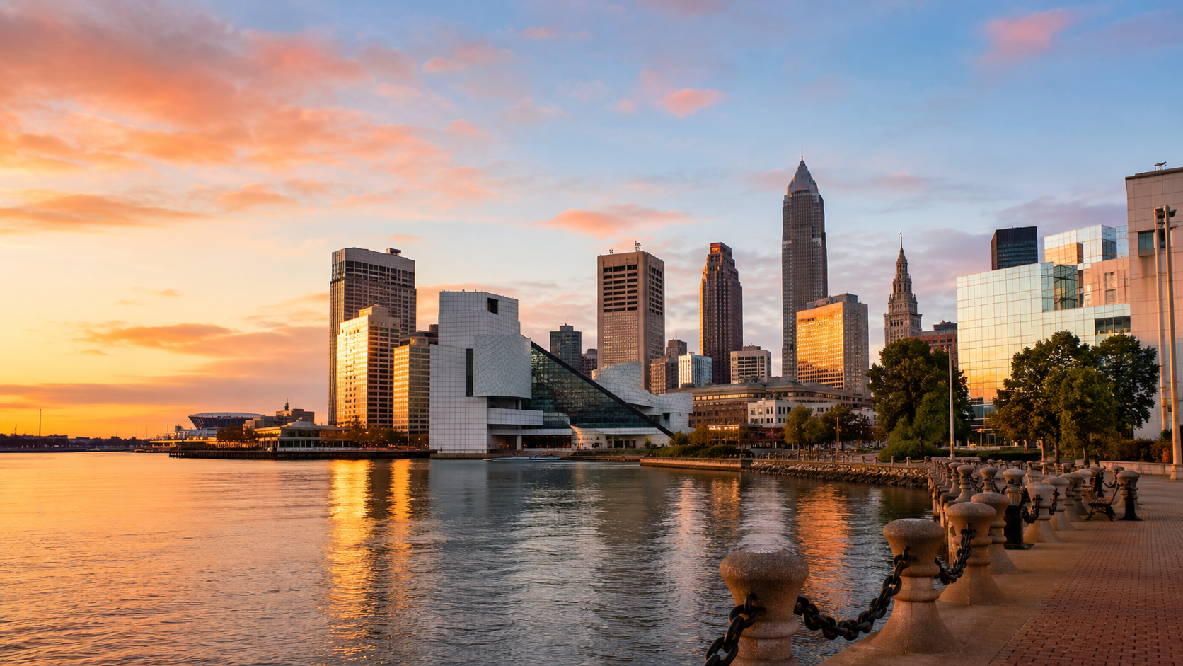 Cleveland skyline at sunset with Lake Erie waterfront, downtown buildings, Rock and Roll Hall of Fame and city promenade.