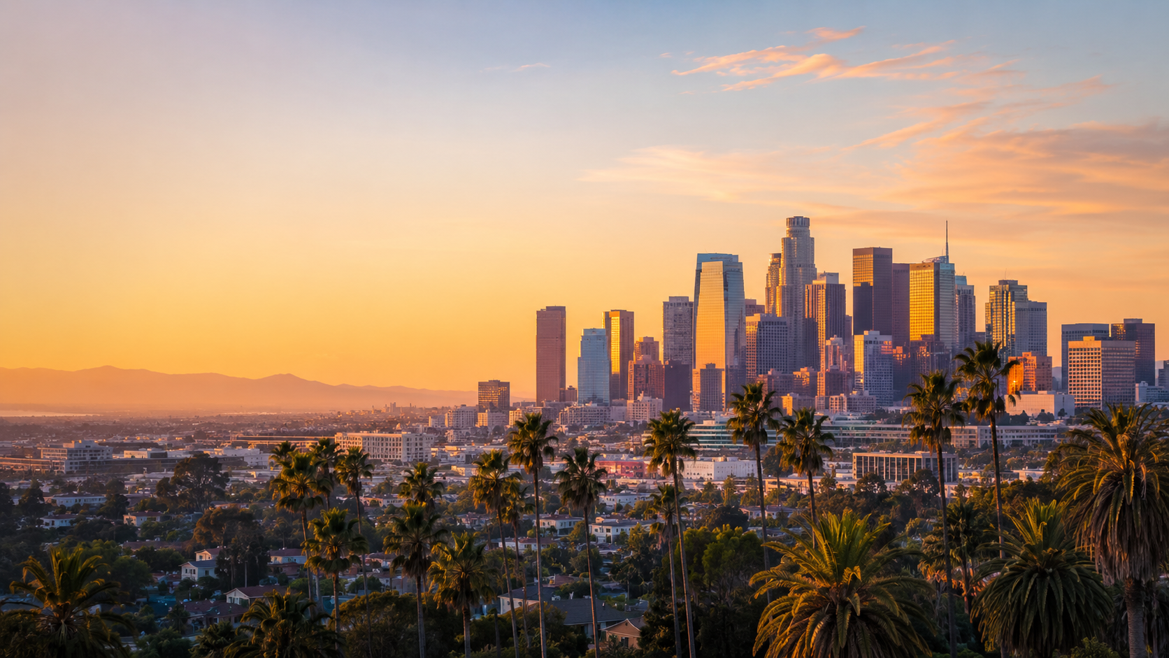 Los Angeles skyline at golden hour with downtown skyscrapers, palm trees and city views in California.