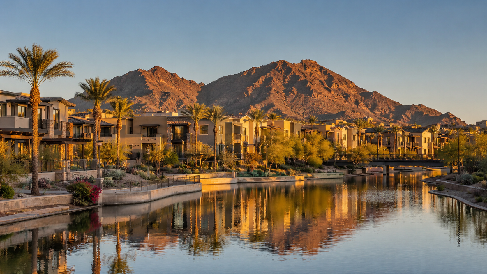 Scottsdale waterfront at golden hour with palm trees, desert-style buildings, mountain backdrop and water reflections in Arizona.