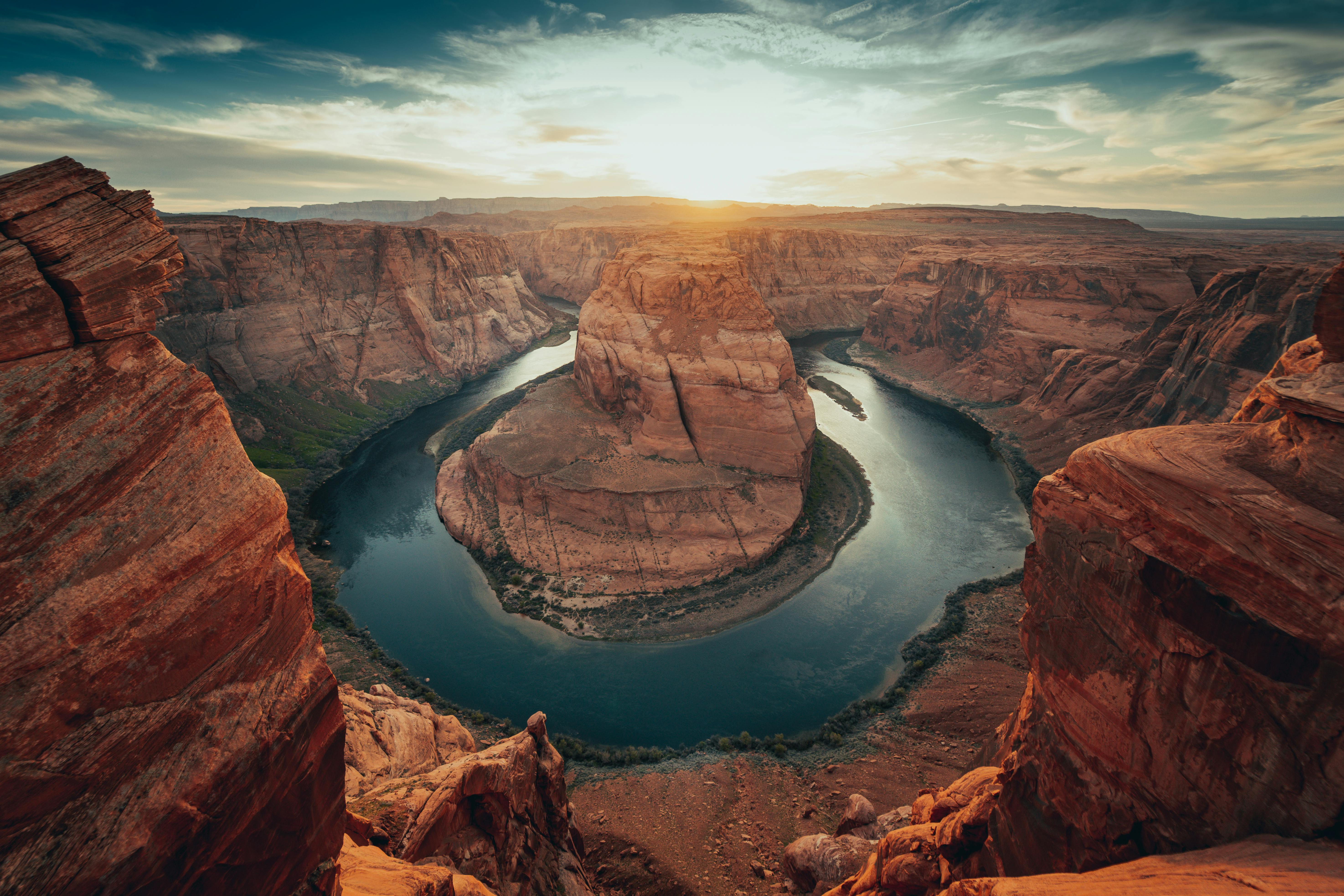 Horseshoe Bend at sunset with the Colorado River winding through red sandstone cliffs in Arizona, United States.